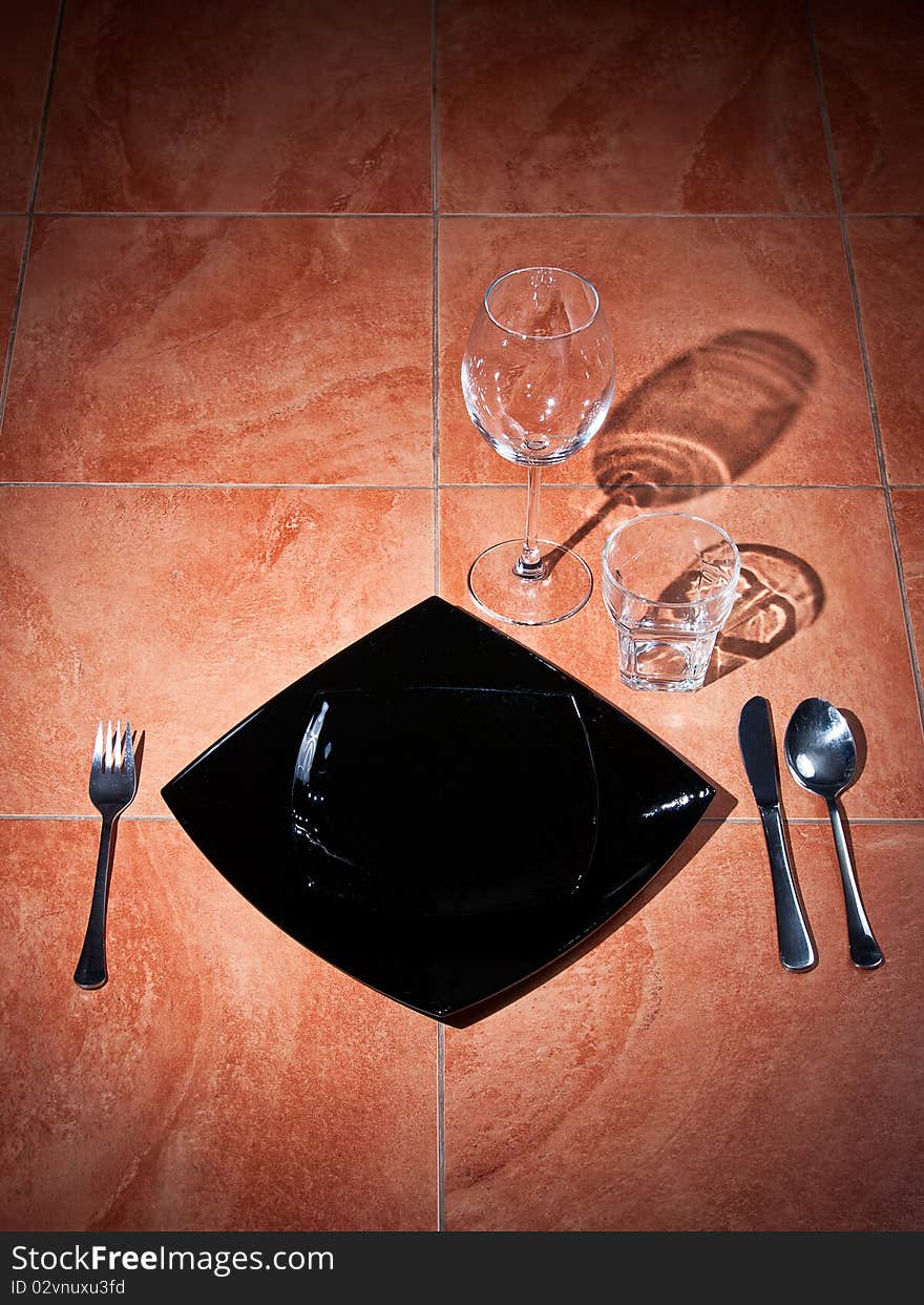 Served tableware on a floor with shadow from glasses. Served tableware on a floor with shadow from glasses