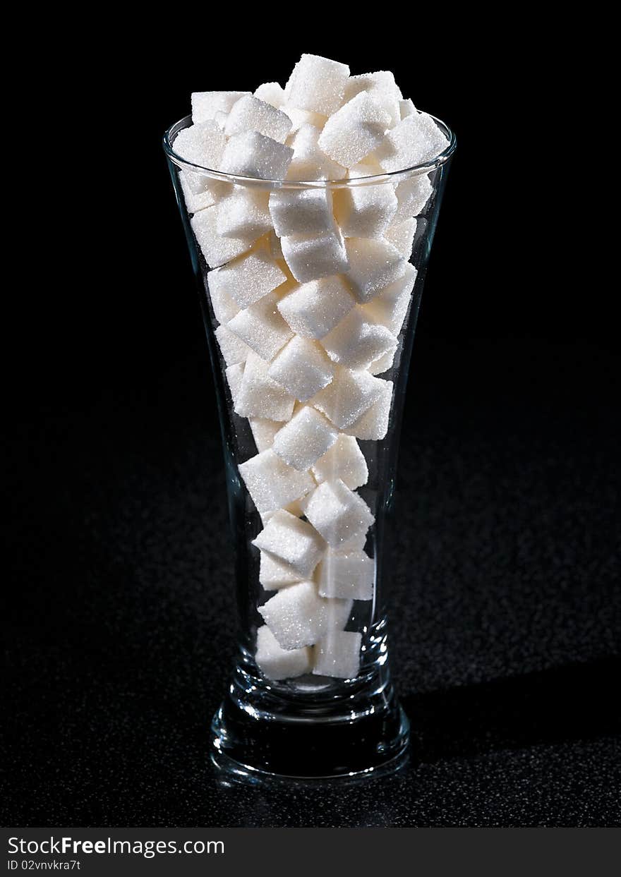 Glass of sugar tubes with dark background. Glass of sugar tubes with dark background