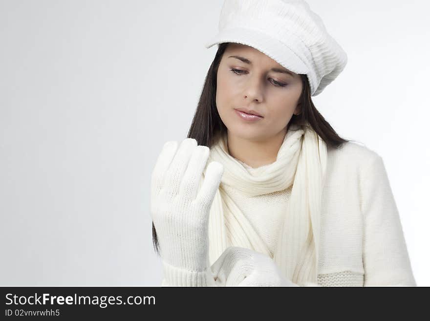 Young woman in soft white sweater and cap, wearing mittens. Young woman in soft white sweater and cap, wearing mittens