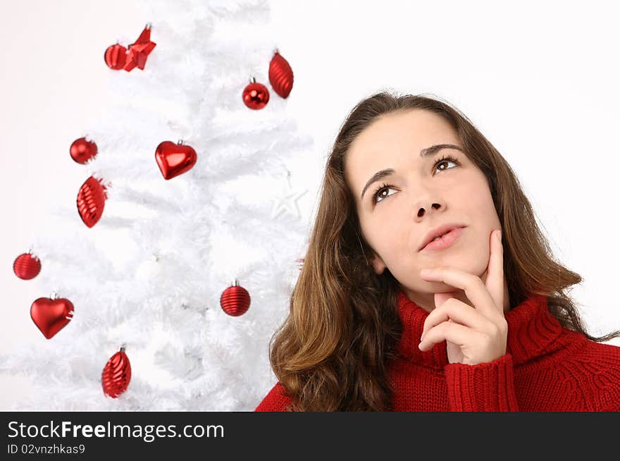 Beautiful young woman next to christmas tree