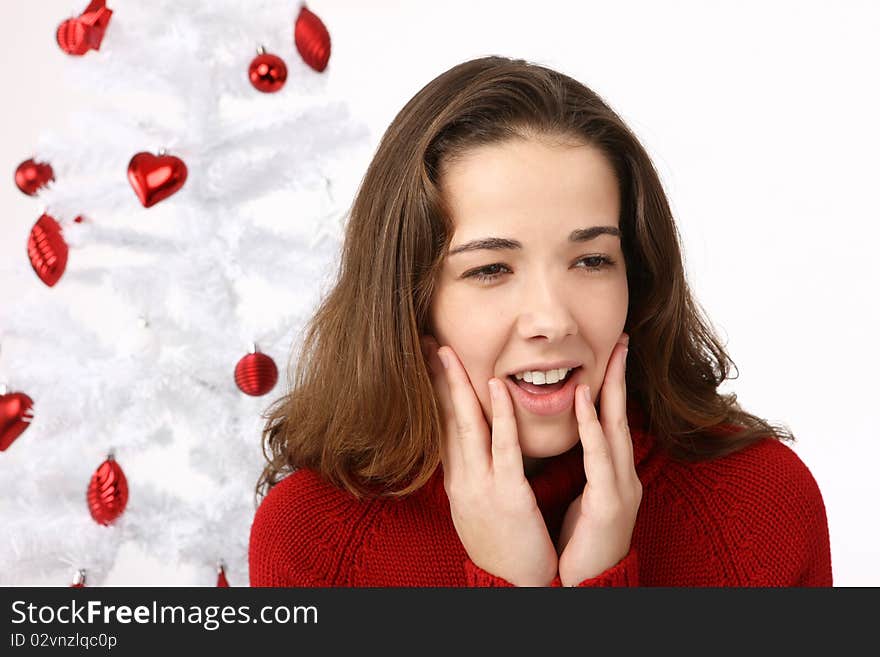 Beautiful young woman next to christmas tree