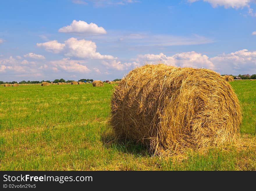 Straw bales on field against sky