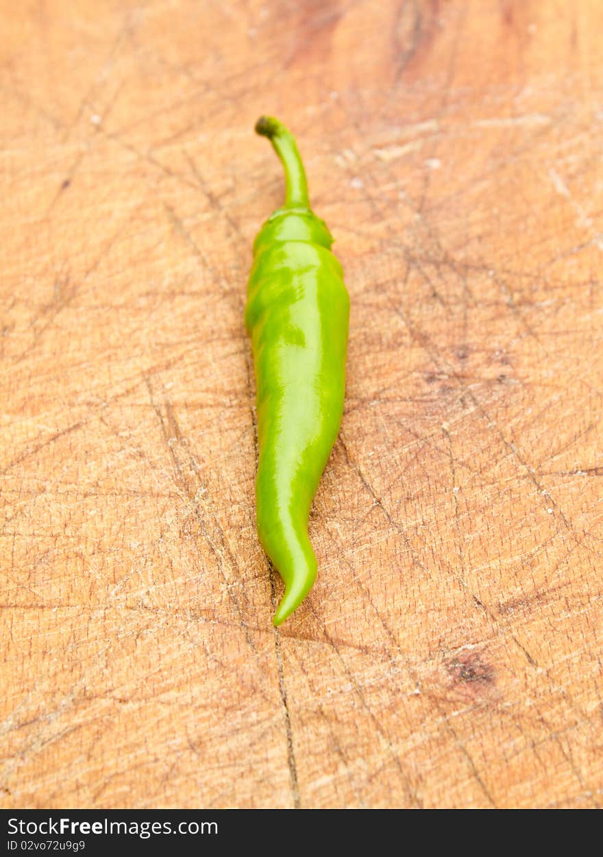 Green chilli pepper on a cutting board