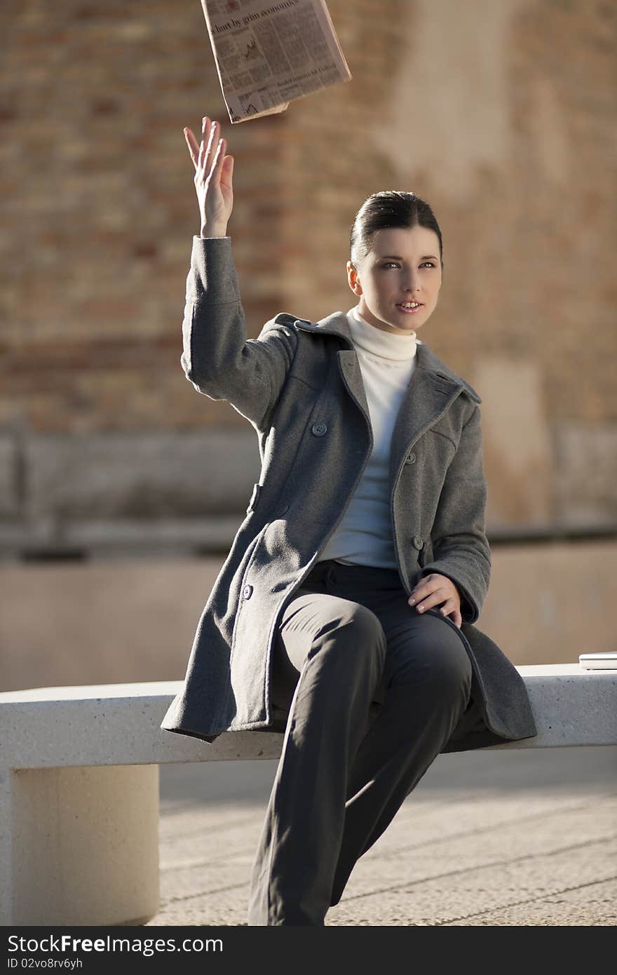 Businesswoman with newspaper on bench