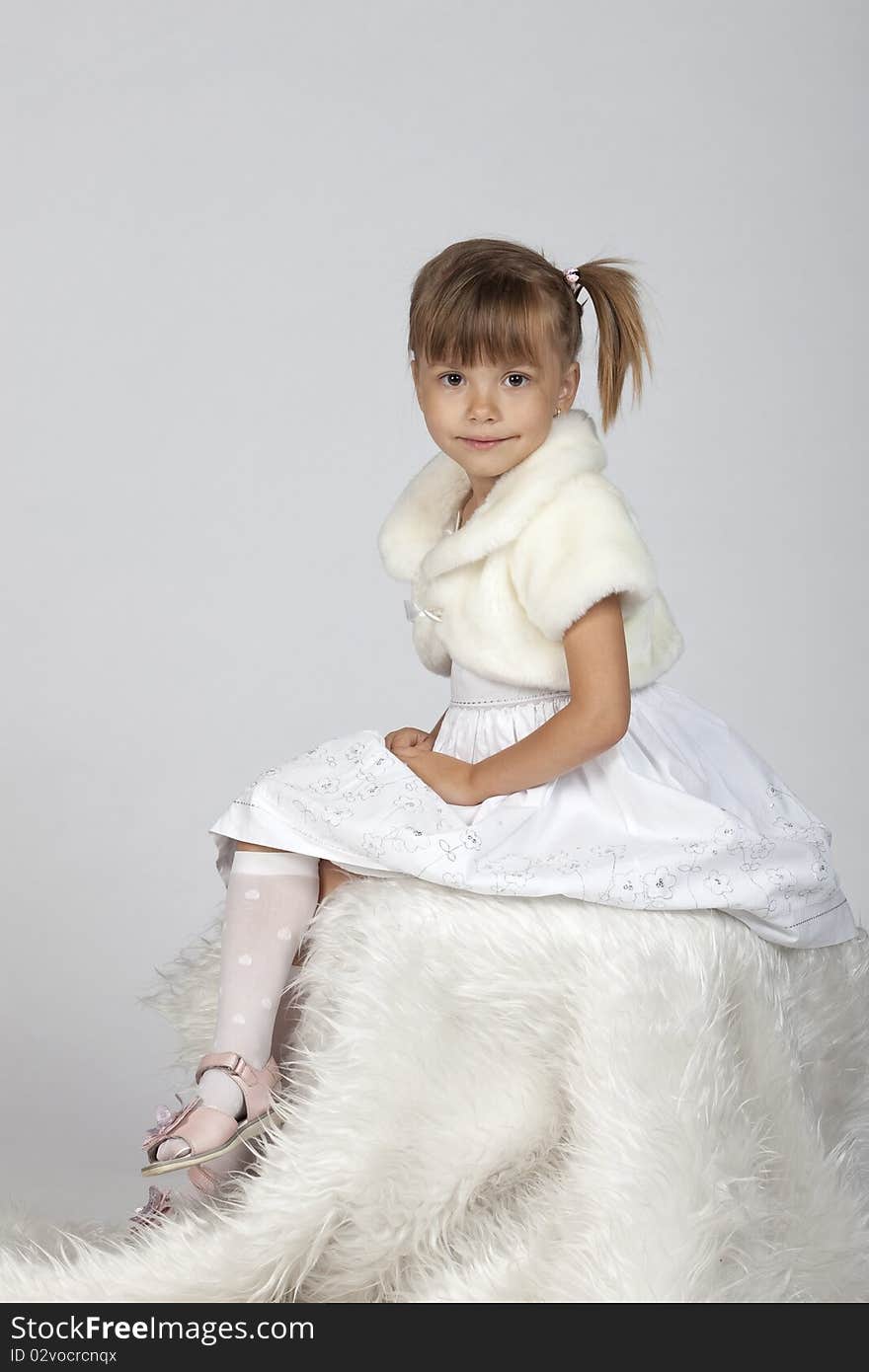 Portrait of a little girl sitting in a studio, winter setup. Portrait of a little girl sitting in a studio, winter setup