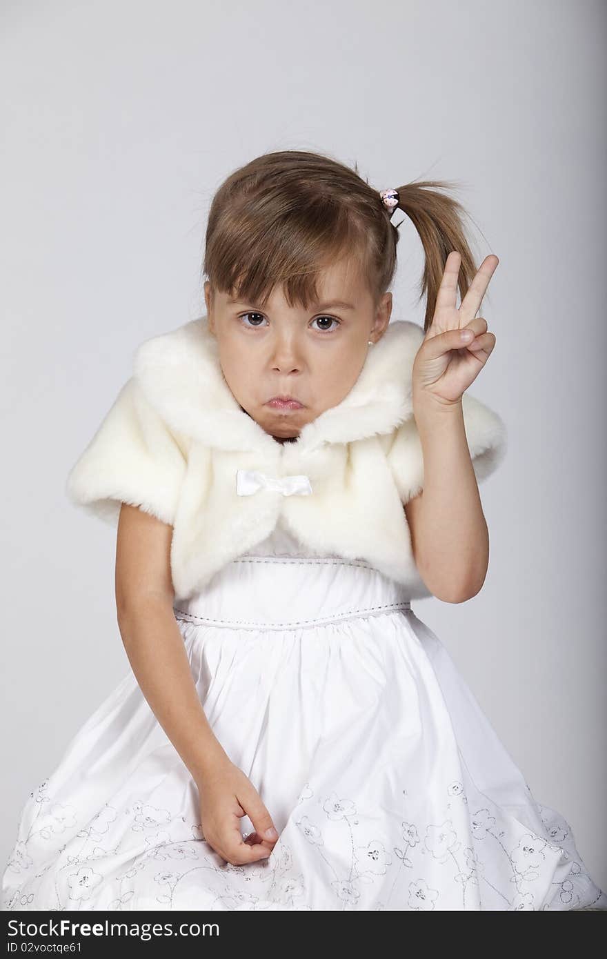 Portrait of an amusing little girl gesturing two fingers up. Portrait of an amusing little girl gesturing two fingers up