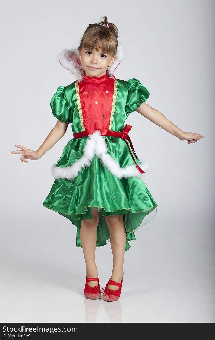 Full length portrait of a cheerful little girl wearing green dress on Saint Patrick's Day, studio image. Full length portrait of a cheerful little girl wearing green dress on Saint Patrick's Day, studio image