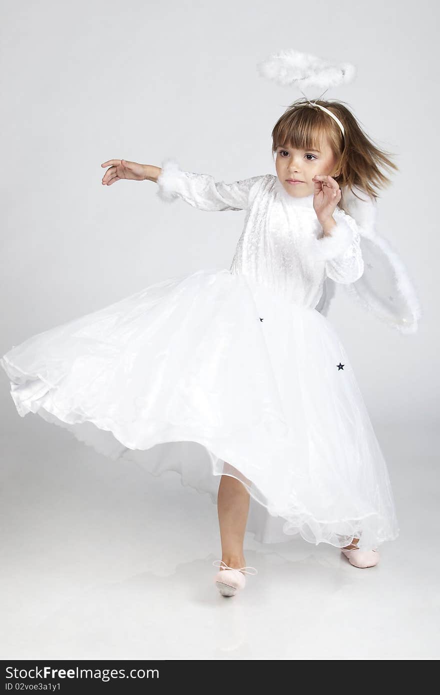 Full length portrait of a lovely little girl dressed as an angel, ready to fly, studio image. Full length portrait of a lovely little girl dressed as an angel, ready to fly, studio image