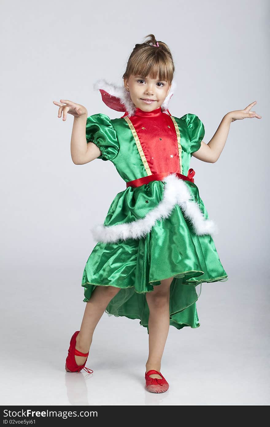 Full length portrait of a cheerful little girl wearing green dress on Saint Patrick's Day, studio image. Full length portrait of a cheerful little girl wearing green dress on Saint Patrick's Day, studio image