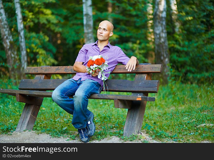 Guy with bouquet waiting for his girlfriend outsid