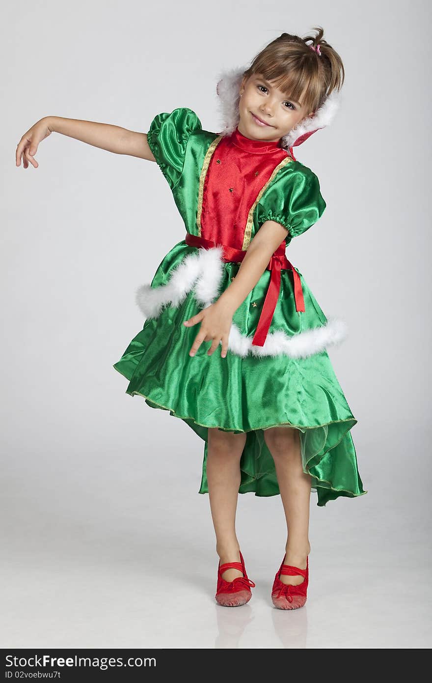 Full length portrait of a cheerful little girl wearing green dress on Saint Patrick's Day, studio image. Full length portrait of a cheerful little girl wearing green dress on Saint Patrick's Day, studio image