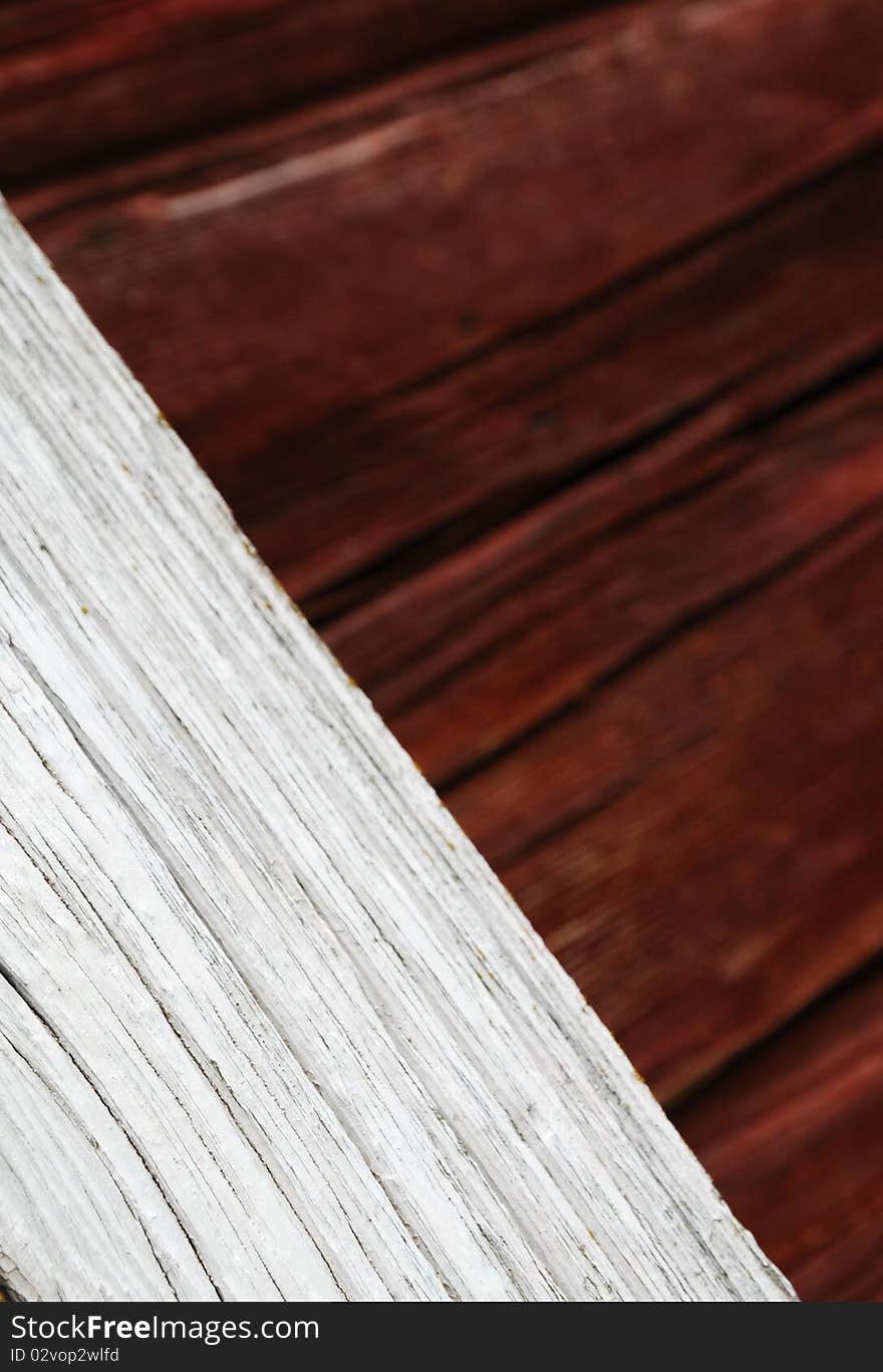 Wood plank is placed diagonally. It is photographed closely and against the wooden wall blurred. The stained board is weathered and chapped. There is copy space. Wood plank is placed diagonally. It is photographed closely and against the wooden wall blurred. The stained board is weathered and chapped. There is copy space.