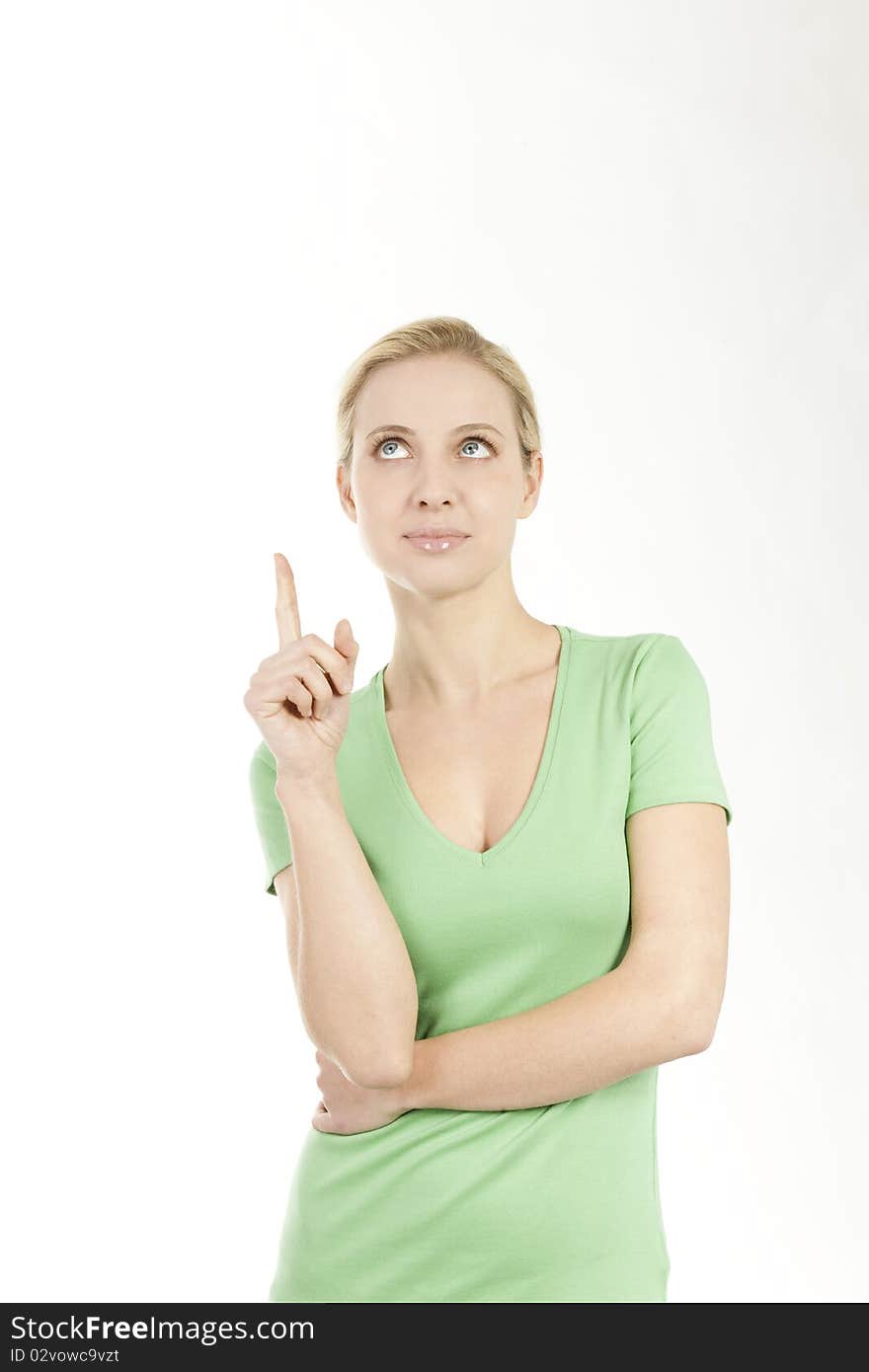 Young woman pointing at copy space; she is green dressed, maybe pointing at something concerned with nature and environment