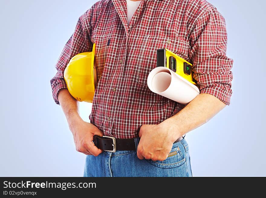 Close-up unrecognizable builder with the tools and a helmet under his arm. Close-up unrecognizable builder with the tools and a helmet under his arm