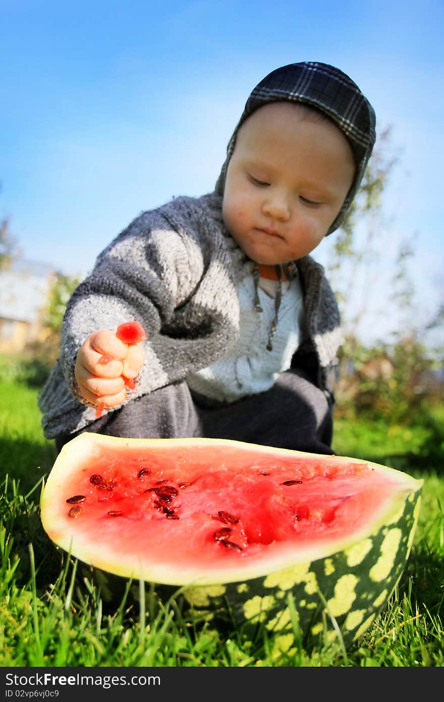 The boy presses a water-melon hands