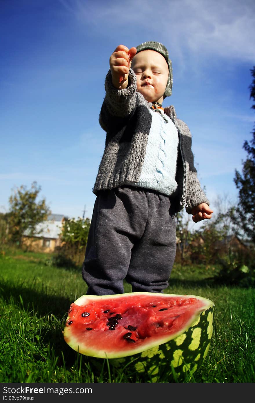 The boy presses a water-melon in hands