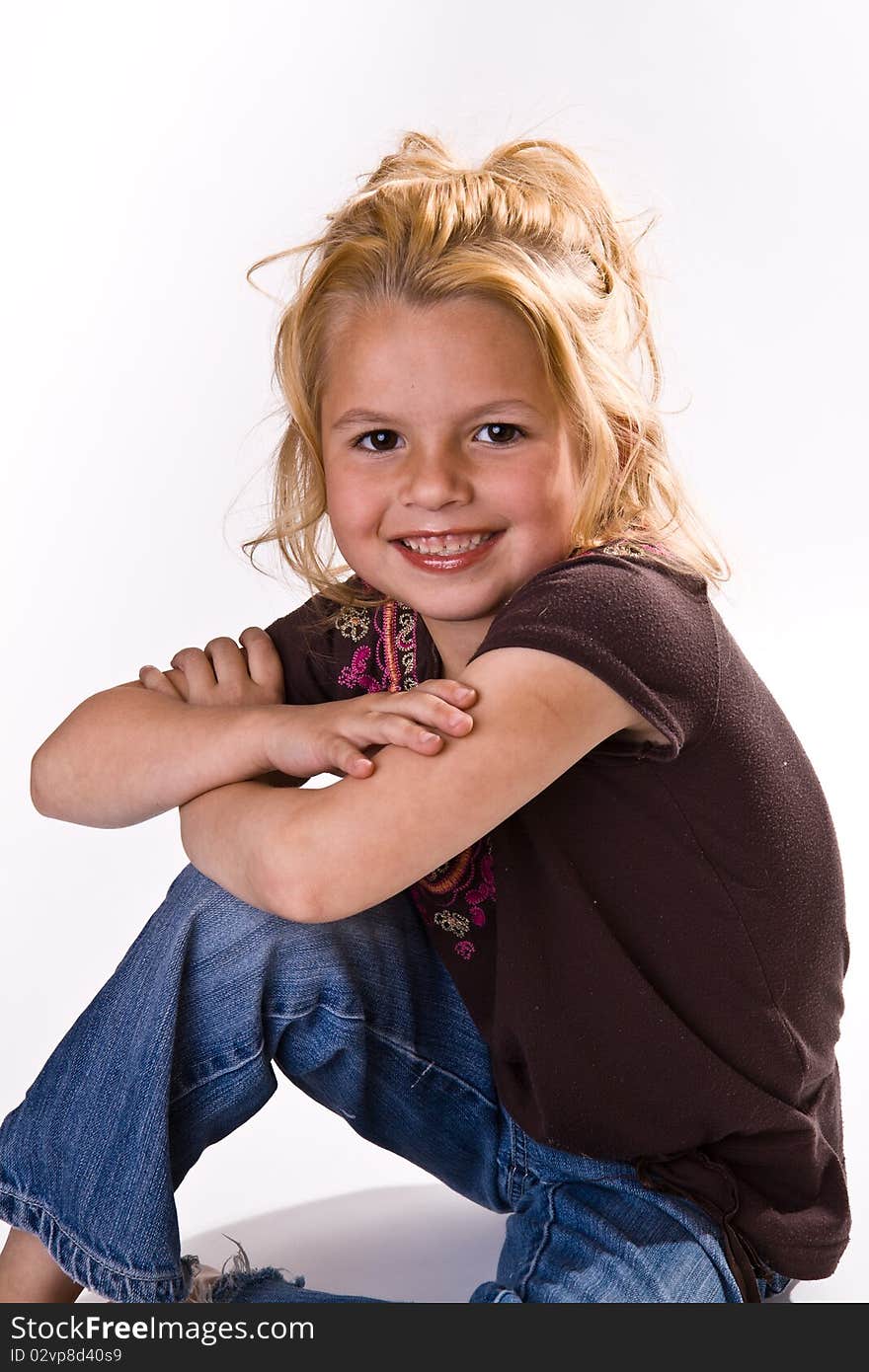 Cute young blond with her arms crossed wearing jeans and a brown shirt. Cute young blond with her arms crossed wearing jeans and a brown shirt.