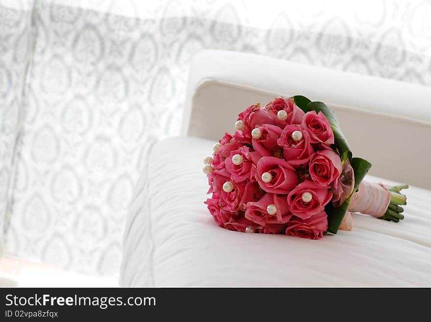 A bouquet of pink roses on a white sofa