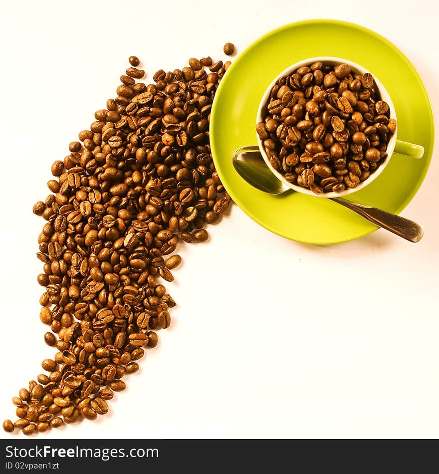 Green cup of coffee with brown beans on white ground