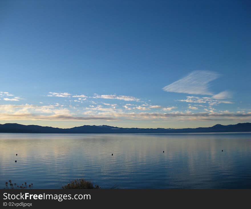 A cloud looks as if its been brushed over the lake while the sun rises. A cloud looks as if its been brushed over the lake while the sun rises