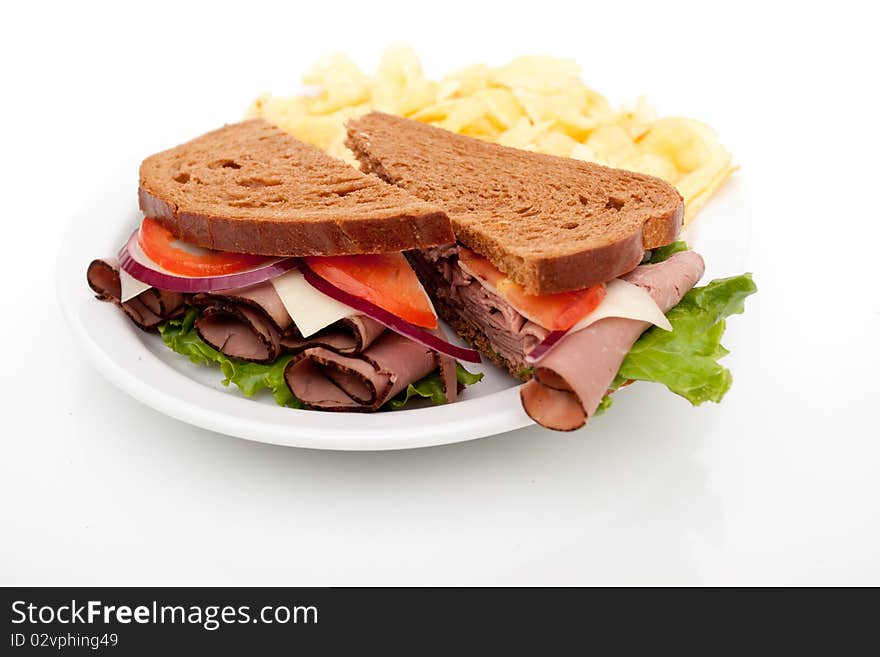 Delicious roast beef sandwich platter with whole wheat bread and potato chips. Delicious roast beef sandwich platter with whole wheat bread and potato chips