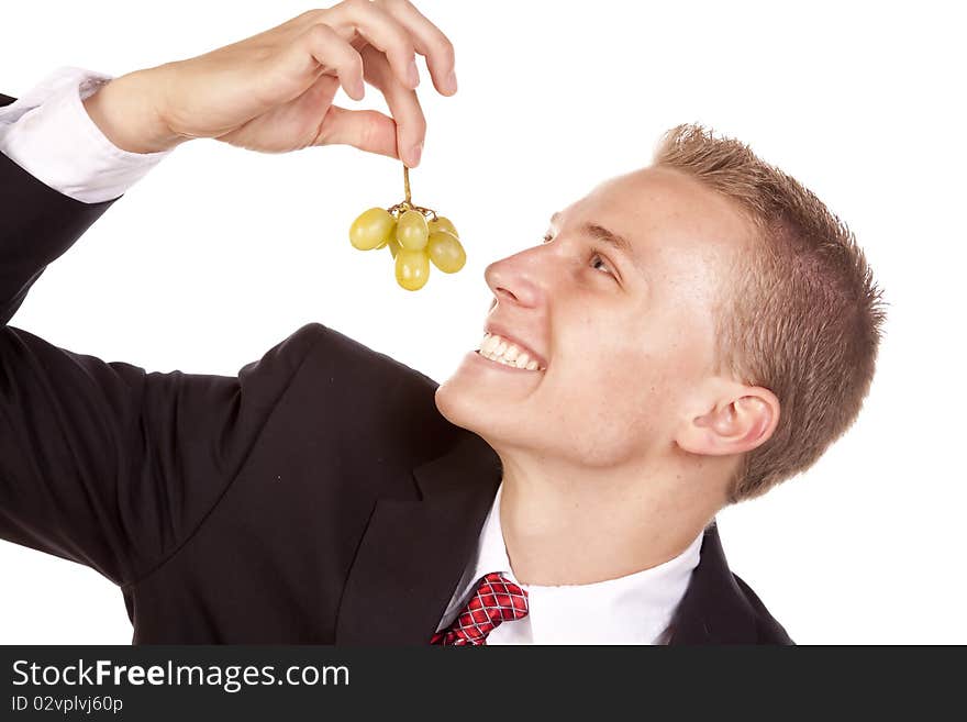 A young man getting ready to eat some green grapes. A young man getting ready to eat some green grapes.