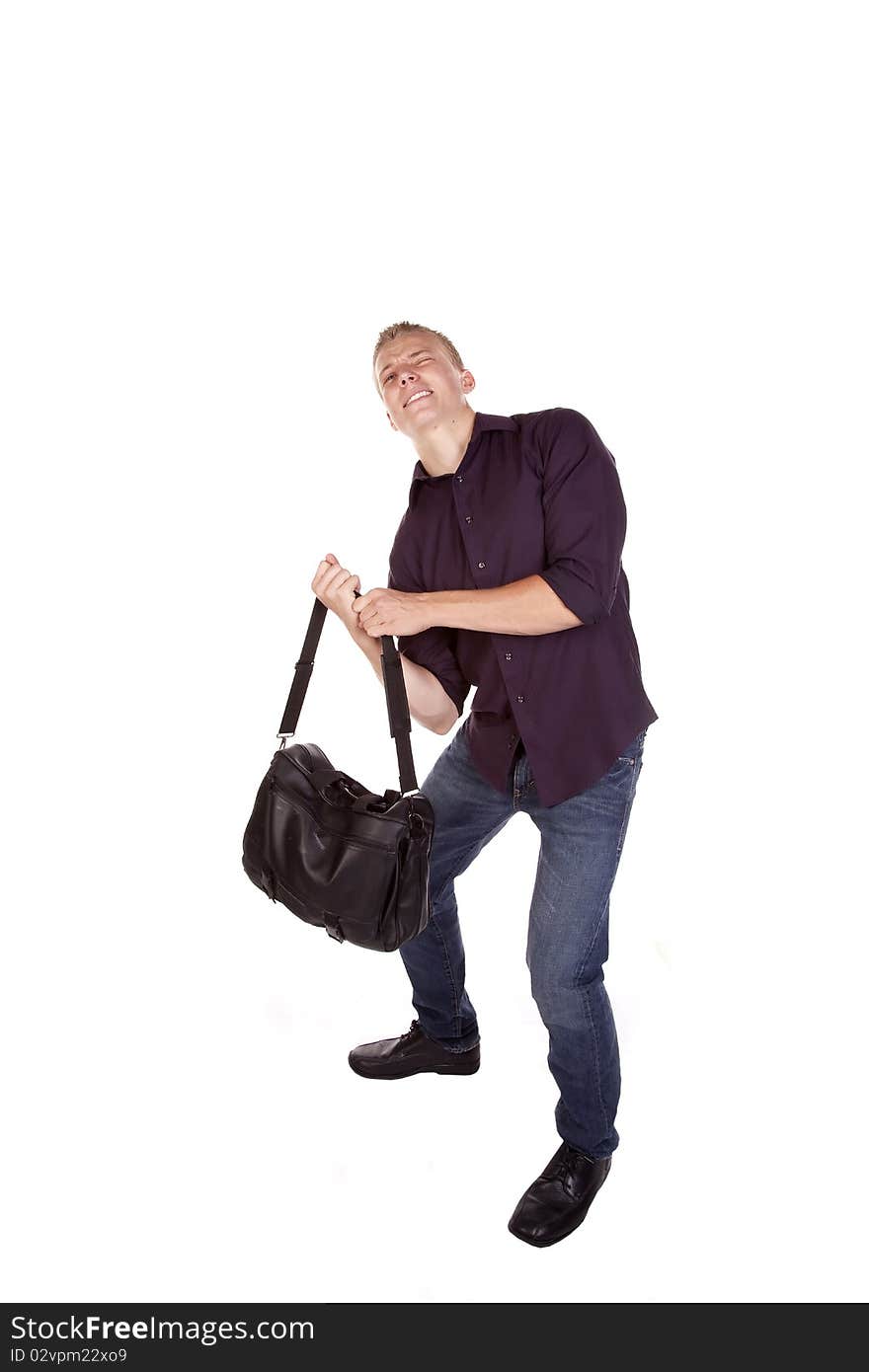 A young man trying to lift his duffel bag off of the ground. A young man trying to lift his duffel bag off of the ground.