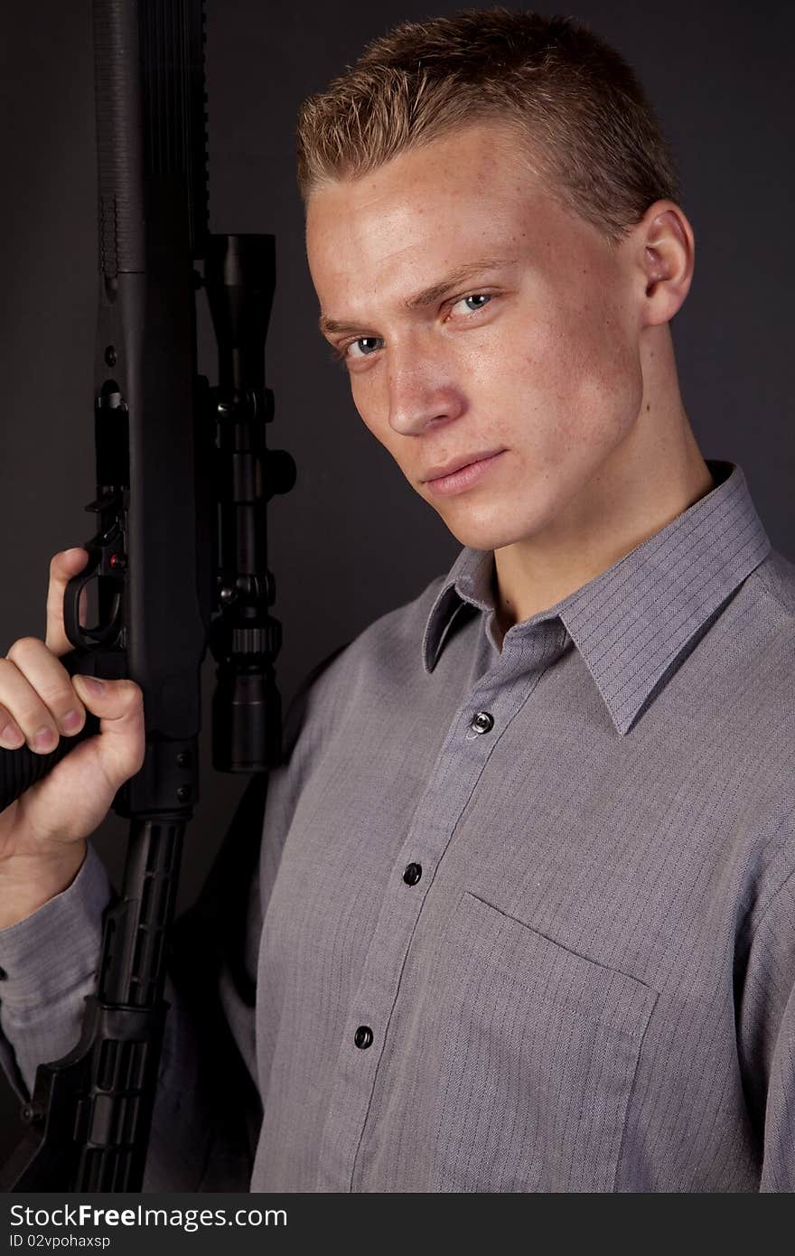 A young man holding his gun looking at the camera. A young man holding his gun looking at the camera.