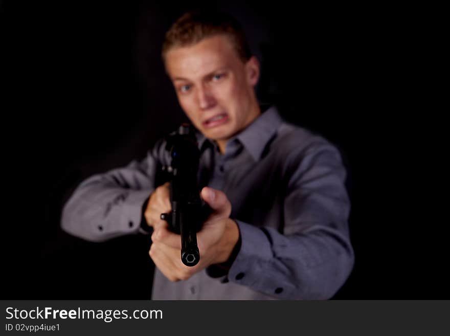 A young man pointing his gun at the camera with a scared expression on his face. A young man pointing his gun at the camera with a scared expression on his face.