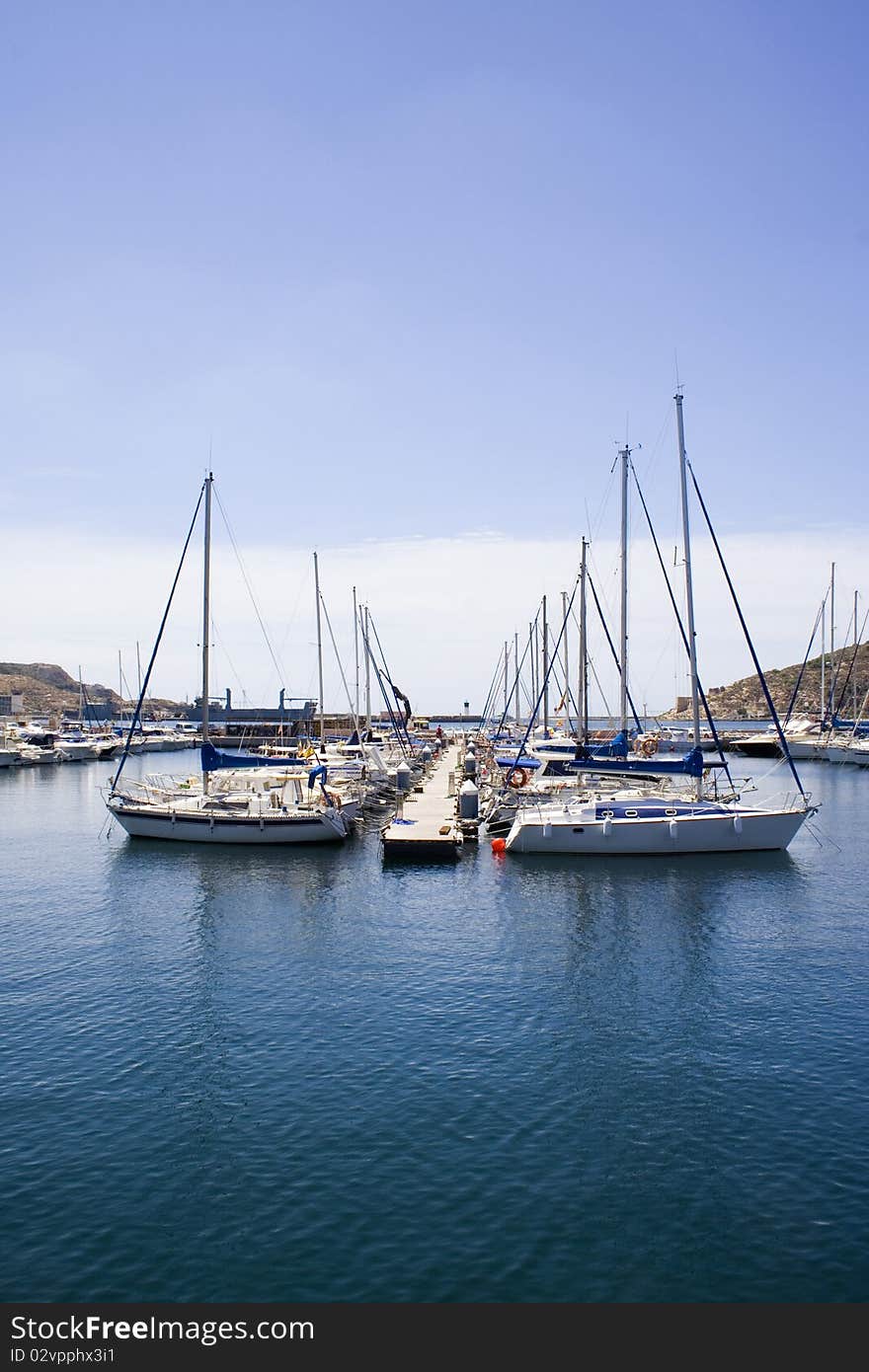 Small yachts moored on a pontoon in a Spanish harbour. Small yachts moored on a pontoon in a Spanish harbour.