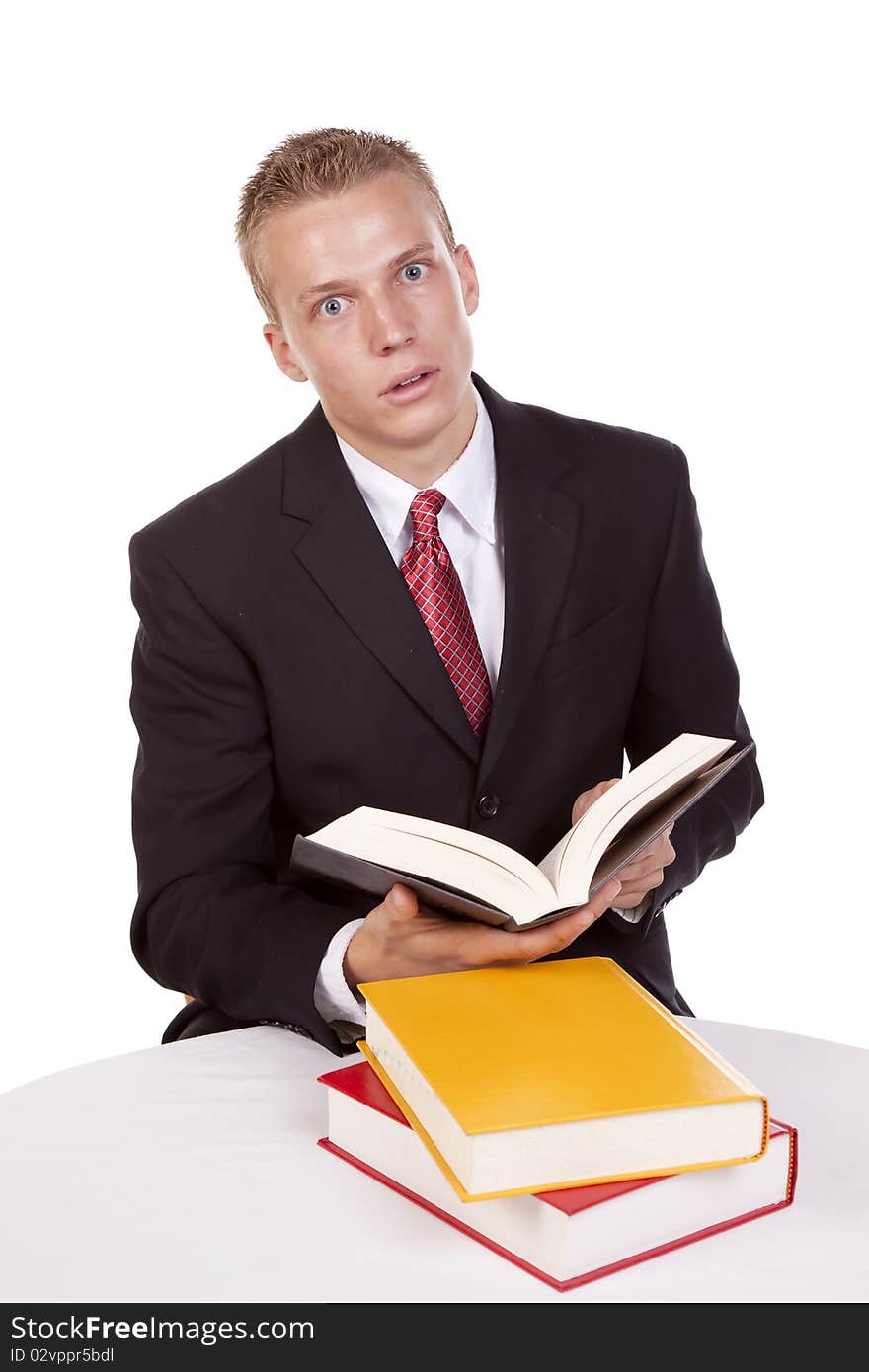 A business man holding a book with an expression of surprise at what he is reading. A business man holding a book with an expression of surprise at what he is reading.