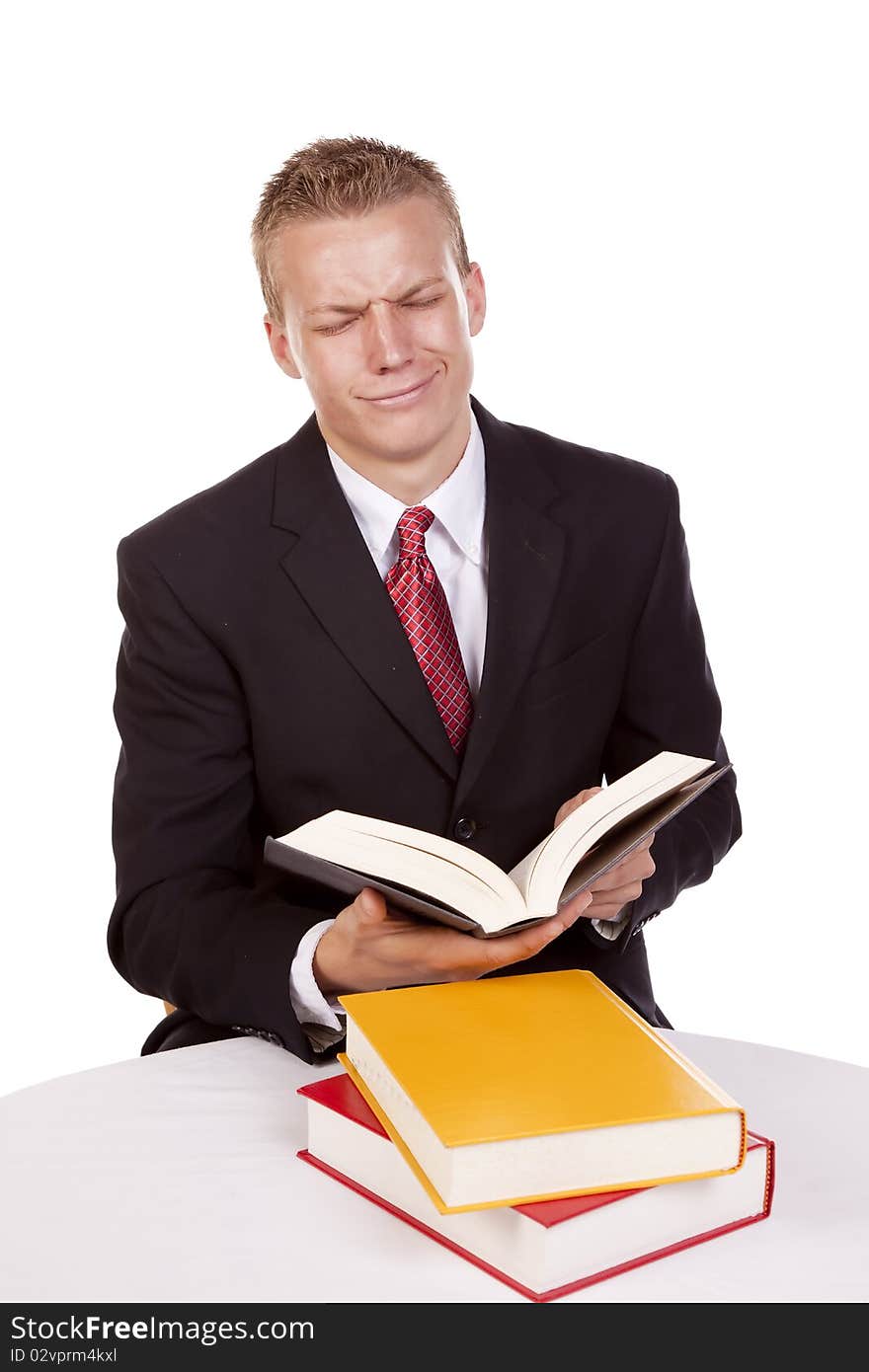 A business man reading and studying wanting to cry about how much work he has.