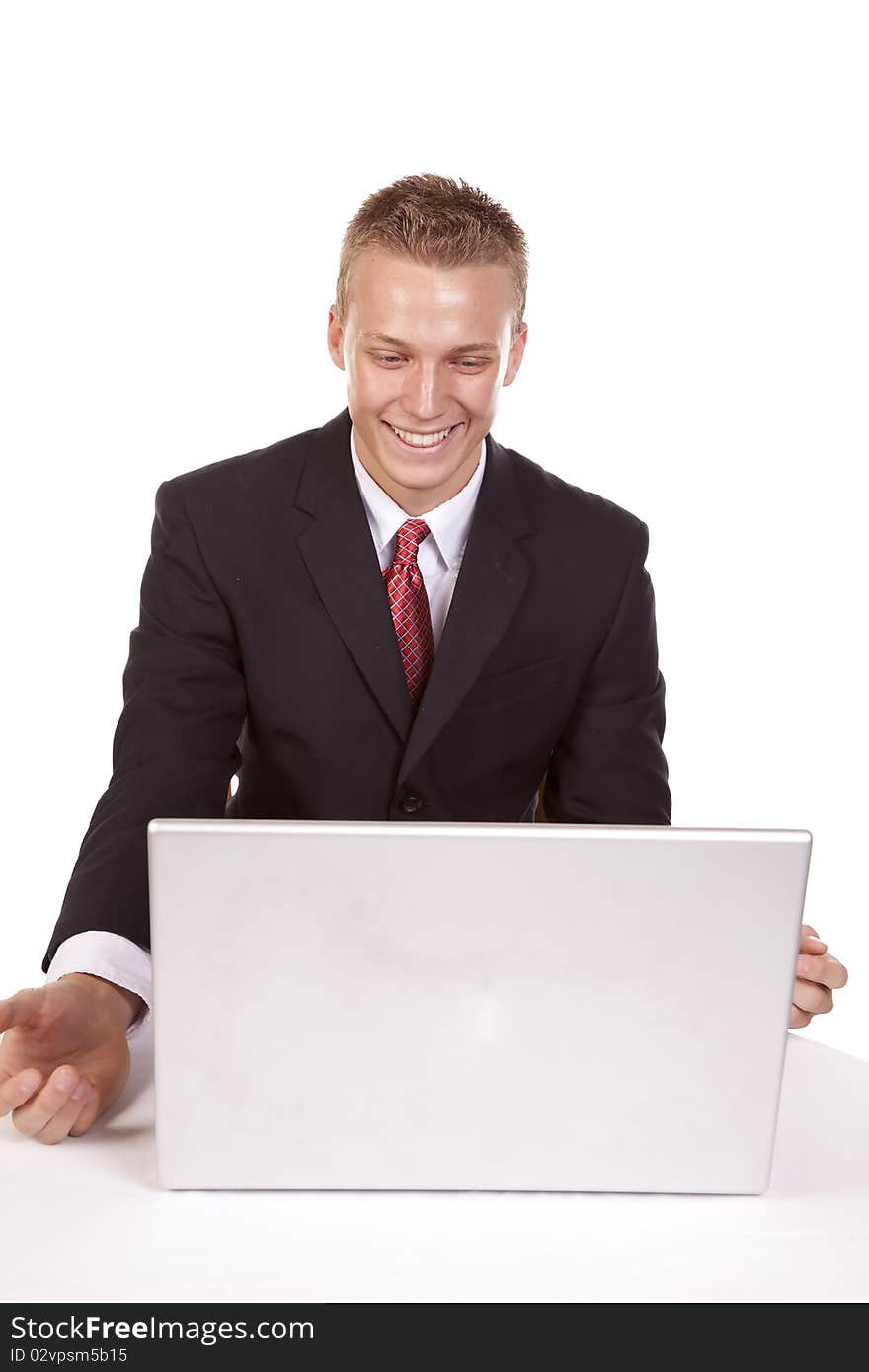 A young man looking at his computer with a happy expression on his face. A young man looking at his computer with a happy expression on his face.