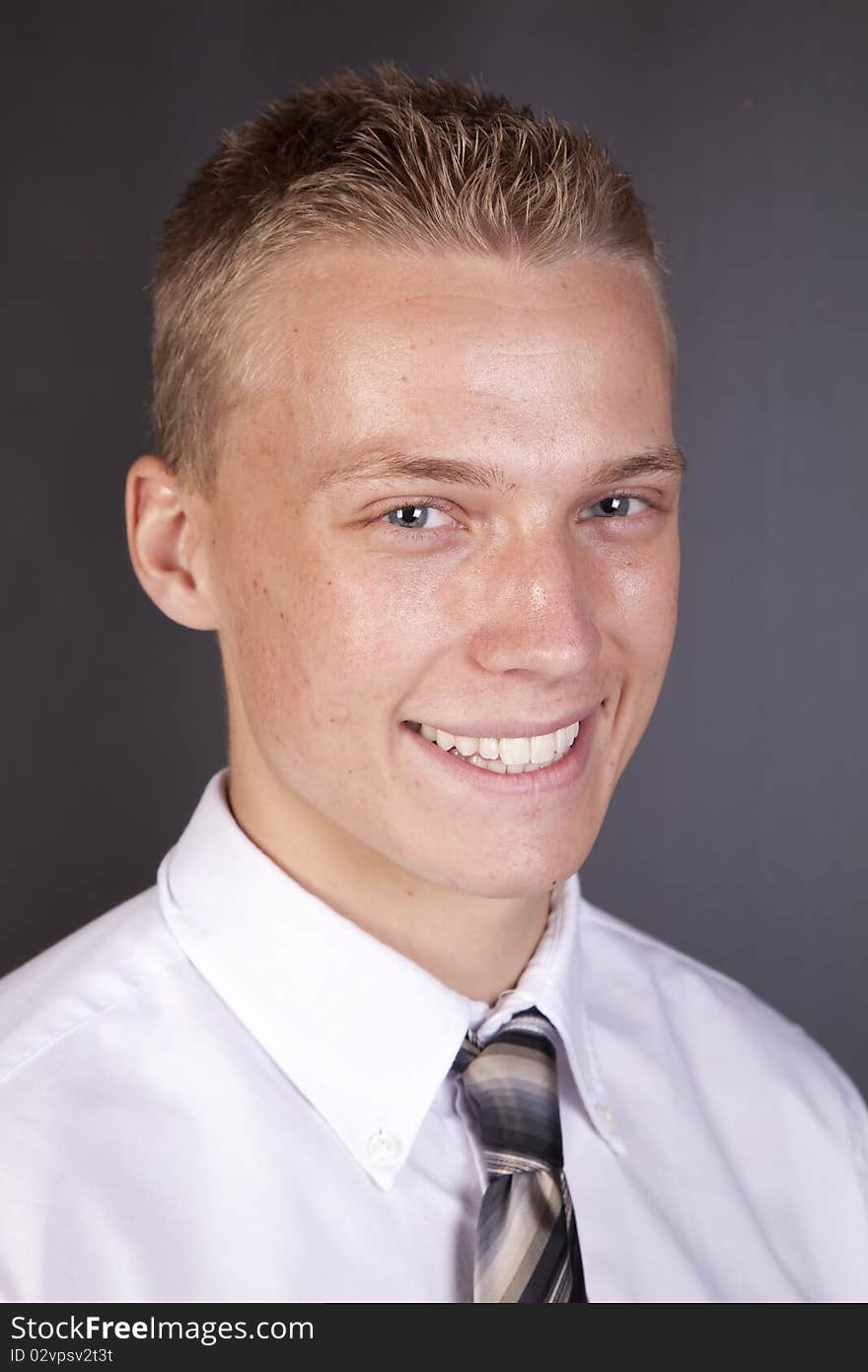 A young man with a shirt and tie on with a happy expression on his face. A young man with a shirt and tie on with a happy expression on his face.