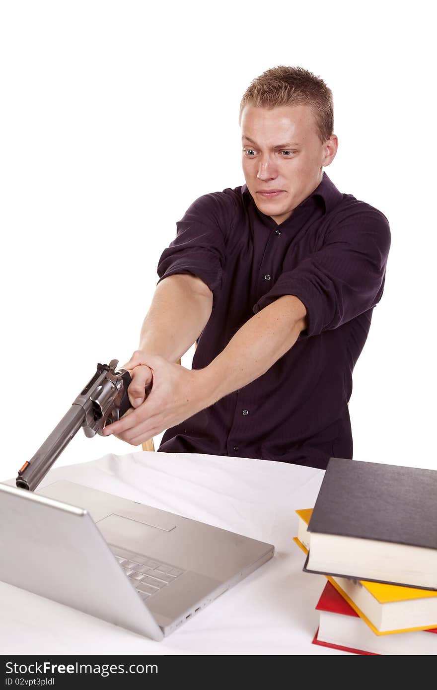 A young man getting ready to shoot his computer because he is so mad. A young man getting ready to shoot his computer because he is so mad.