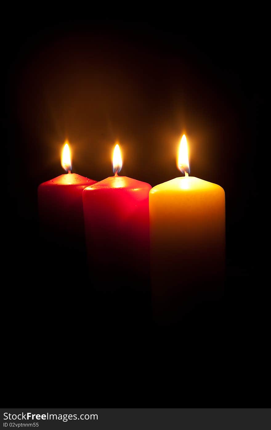 Group of three different burning candles in darkness. Group of three different burning candles in darkness