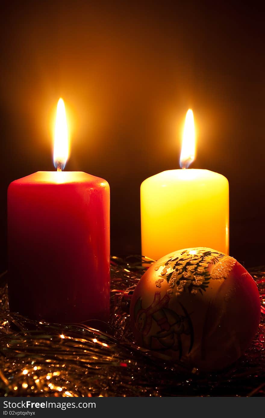 Group of two candles and glass fur-tree sphere in darkness. Group of two candles and glass fur-tree sphere in darkness