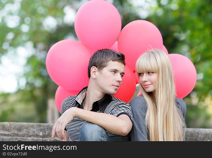 Young loving couple with red balloons