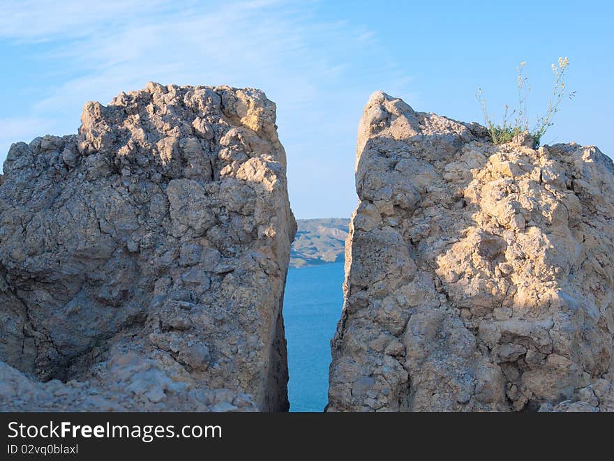 Crack in a rock through which the sea and the sky is visible