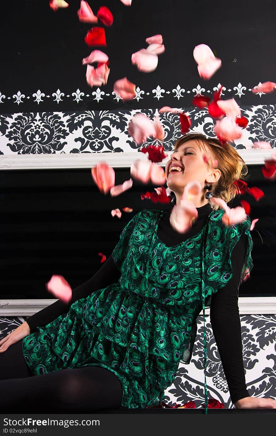 Young lady enjoying rose petals fall