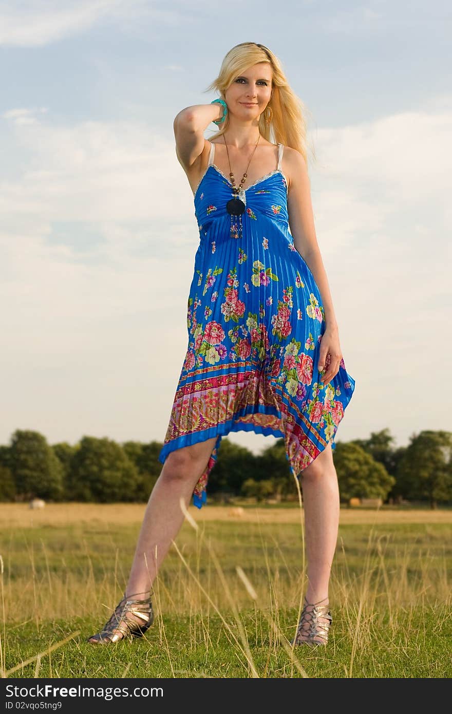 A young woman posing in a field looking beautiful. A young woman posing in a field looking beautiful