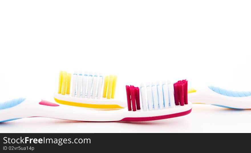 Red and yellow toothbrushes isolated on white