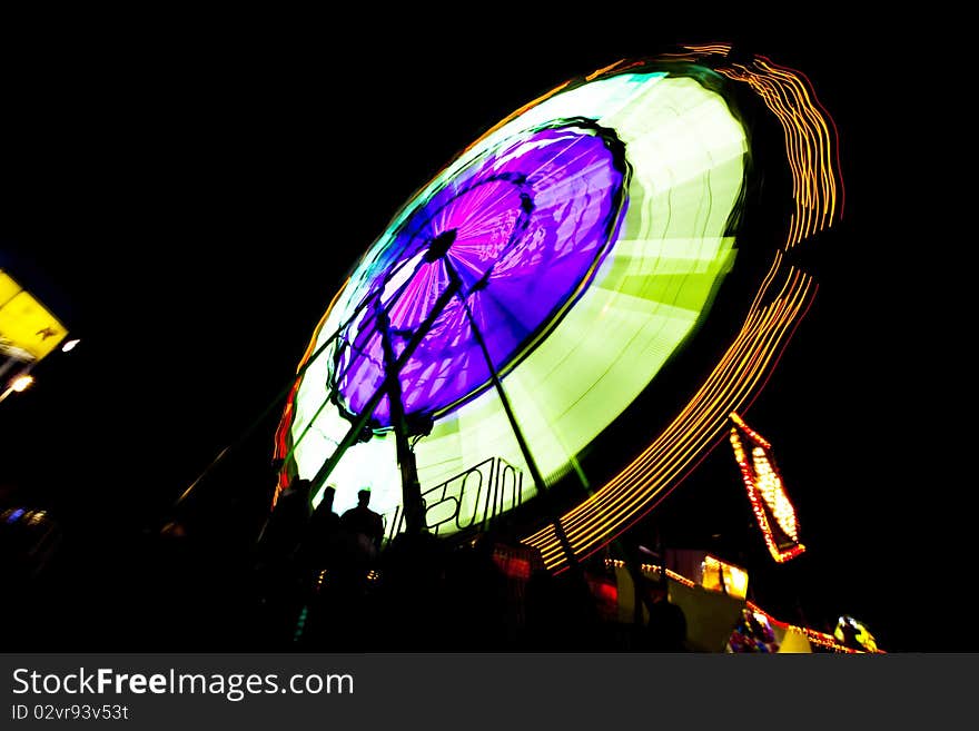 Circular and brightly lit county fair ride at night. Circular and brightly lit county fair ride at night