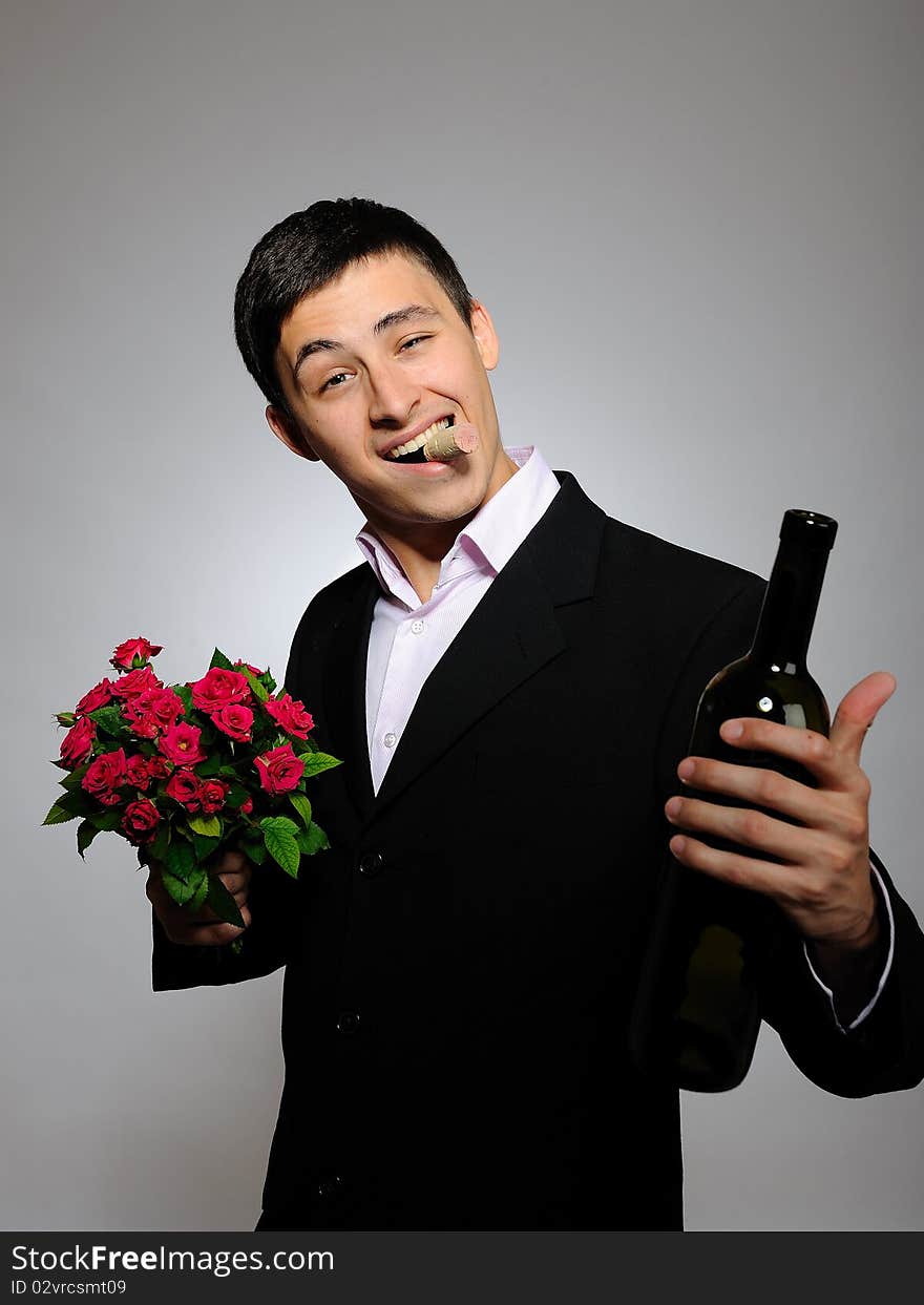 Young man holding rose flower and vine bottle