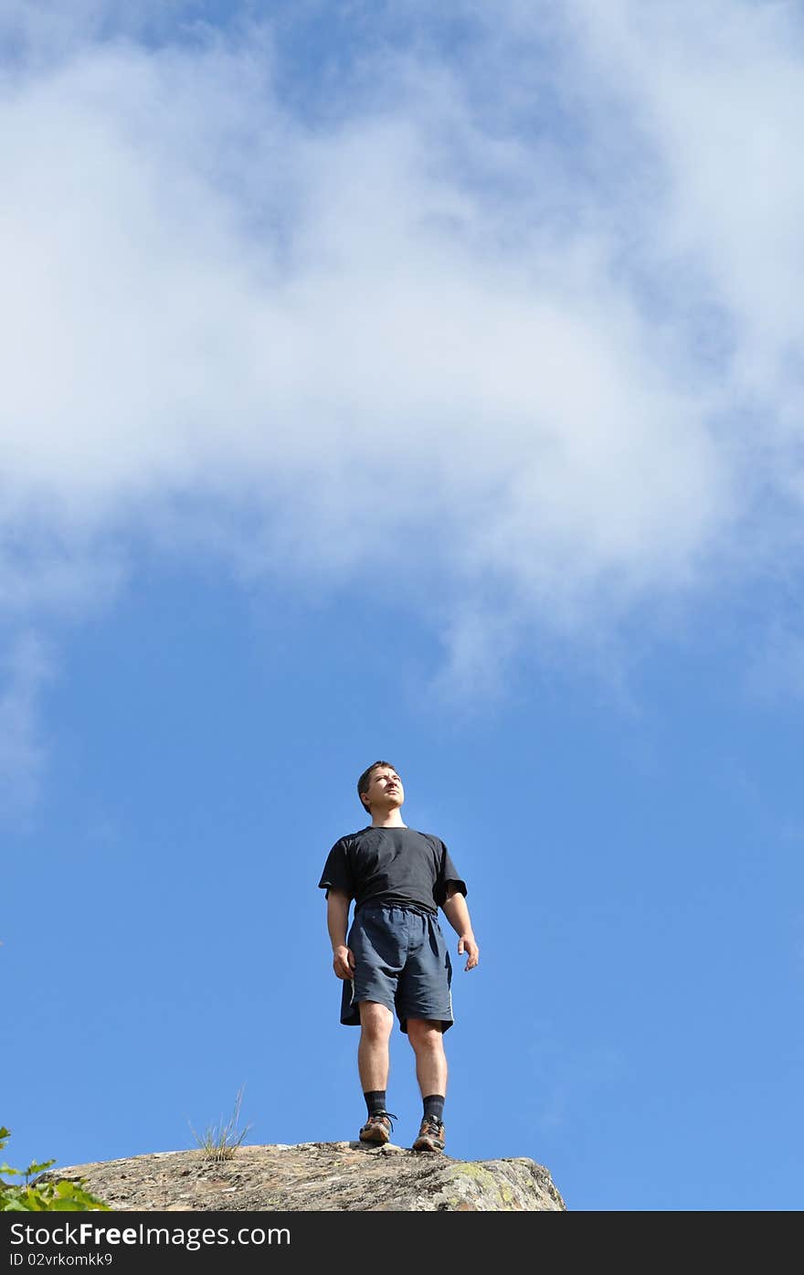 A Young Man Stands On A Cliff Top, And Seriously