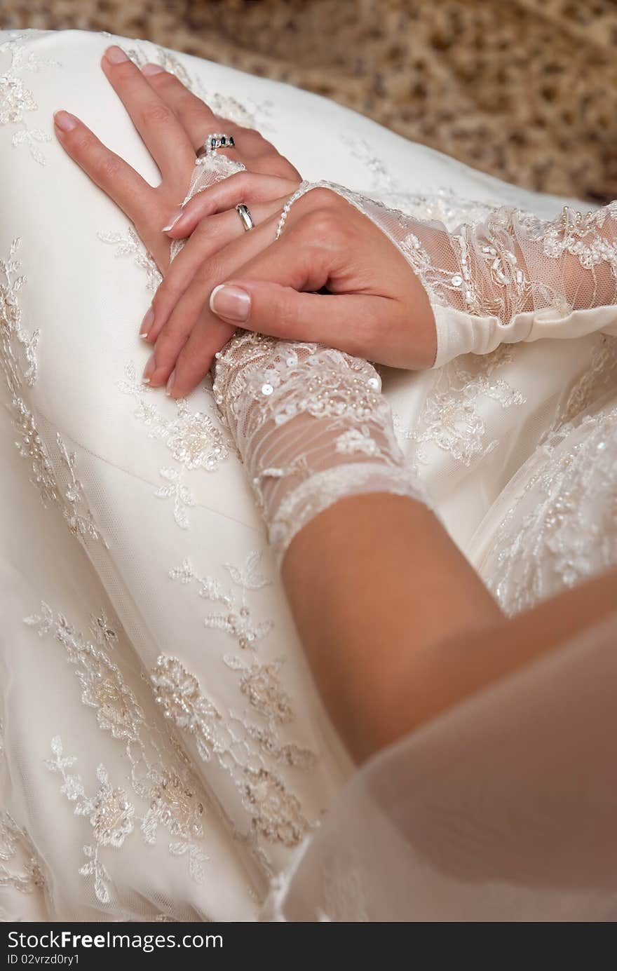 Close-up photo of the bride's hands in white gloves