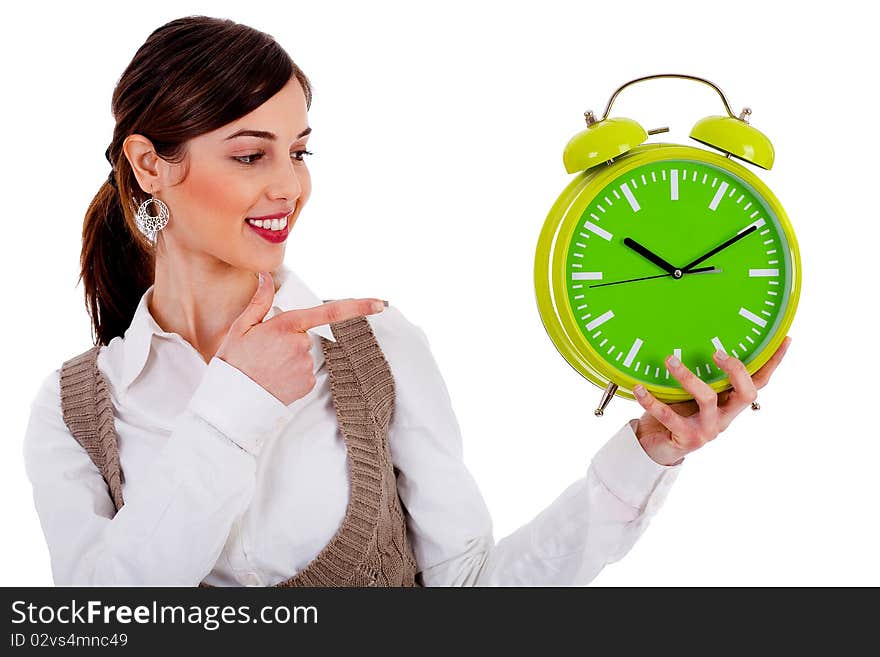 Half view of lady holding alarm clock and pointing at it on an isolated white background. Half view of lady holding alarm clock and pointing at it on an isolated white background