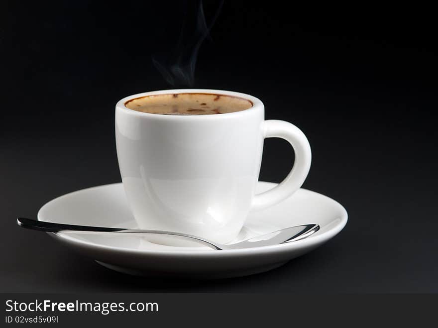 Hot coffee in white cup on black background.