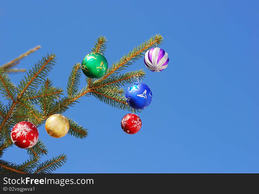 Christmas and New Year decoration - multicolored balls on forest background. Christmas and New Year decoration - multicolored balls on forest background