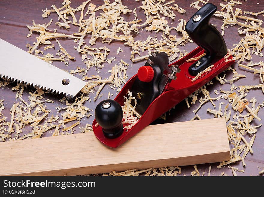 Red plane, wooden brick, handsaw